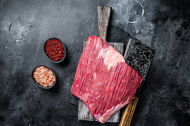 Ongekookt rauw rundvlees braadvlees op het slagerbord. Zwarte achtergrond. Bovenaanzicht. - Foto, afbeelding