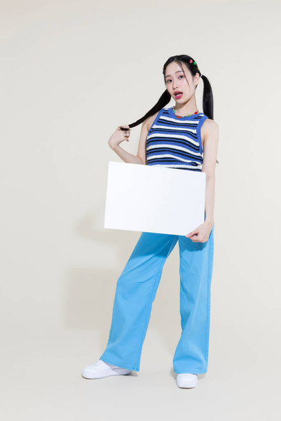 vintage y2k retro concept photo of korean asian cute woman holding a frame panel against studio background - Photo, Image
