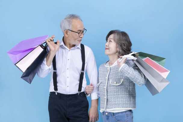 active young senior Korean Asian couple holding shopping bags - Foto, immagini