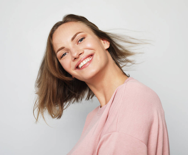 Portrait of cheerful pretty young woman wearing pink sweatshirt - Zdjęcie, obraz