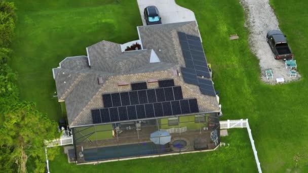 Standaard Amerikaanse woonhuis met dak bedekt met zonne-fotovoltaïsche panelen voor de productie van schone ecologische elektrische energie in voorstedelijke landelijke gebied. Begrip autonoom huis. - Video