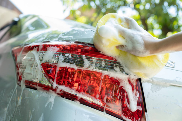 női kéz-a sárga szivacs autó mosás - Fotó, kép
