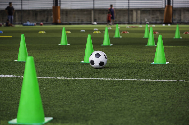 Tactiques de ballon de football cône sur gazon avec pour formation arrière-plan Entraînement des enfants dans le football - Photo, image