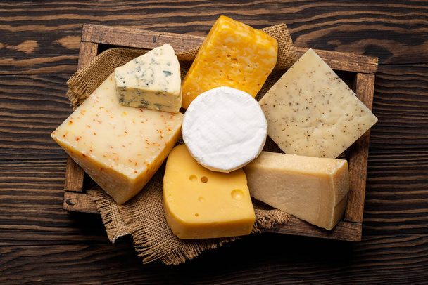 Various cheese in wooden box. Flat lay - Foto, Imagen