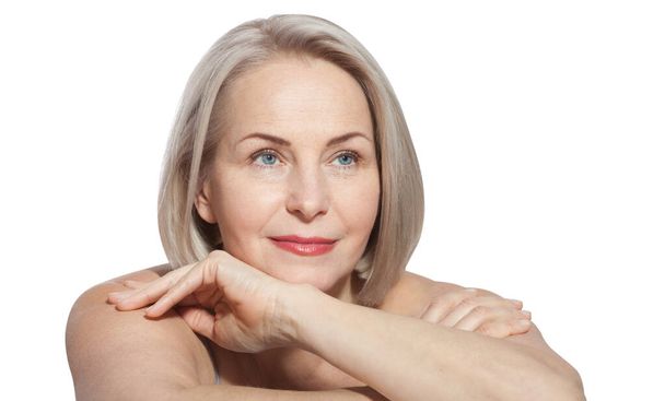 Beautiful middle-aged blonde woman shows off her perfectly well-groomed face isolated. Macro face. Realistic images with their own imperfections. - 写真・画像