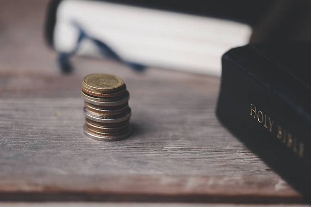 Το ένα δέκατο ή το δέκατο είναι η βάση πάνω στην οποία η Αγία Γραφή μας διδάσκει να δωρίζουμε το ένα δέκατο του πρώτου καρπού στο Θεό. Νομίσματα με την Αγία Γραφή. Δωρεά και χρηματοδότηση θρησκείας. Δίνοντας χρήματα, το σύμβολο της δωρεάς του Χριστιανισμού - Φωτογραφία, εικόνα