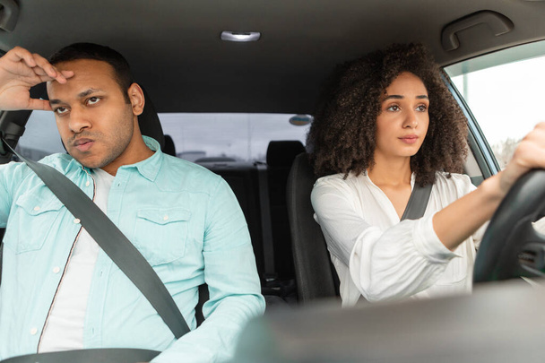 Angry Arab Man Sitting On Passengers Seat While His Wife Driving Their New Car. Novice Driver Woman Having Problems During Automobile Ride, Learning To Drive With Discontented Instructor - Foto, afbeelding