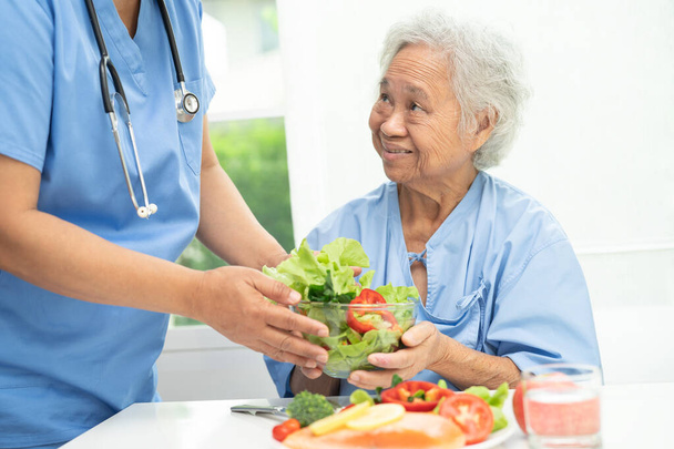 Asiatico anziana donna paziente mangiare salmone bistecca colazione con verdura sano cibo in ospedale. - Foto, immagini