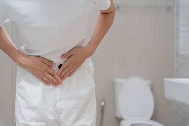 Constipation and diarrhea in bathroom. Hurt woman touch belly  stomach ache painful. colon inflammation problem, toxic food, abdominal pain, abdomen, constipated in toilet, stomachache, Hygiene - Zdjęcie, obraz