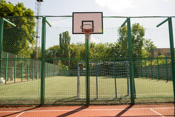 Cerceau de basket rouge avec filet avec fond de feuilles vertes. Concept sportif - Photo, image