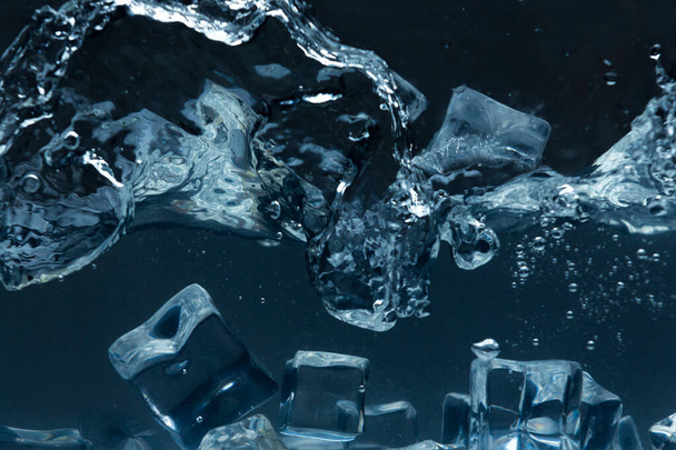 cubitos de hielo que caen sobre agua fría - Foto, Imagen