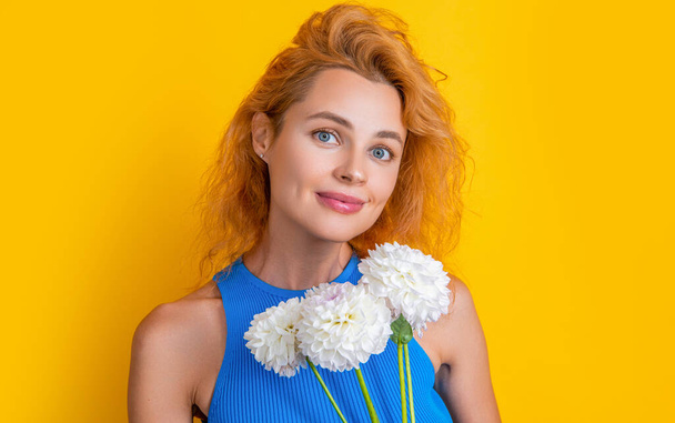 smiling woman with spring flowers. woman with spring flowers isolated on yellow. woman with spring flowers in studio. woman with spring flowers on background - Foto, afbeelding