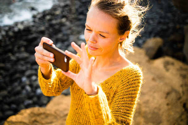 Mooie, jonge vrouw maakt foto 's met haar smartphone tijdens haar vakantie - Foto, afbeelding