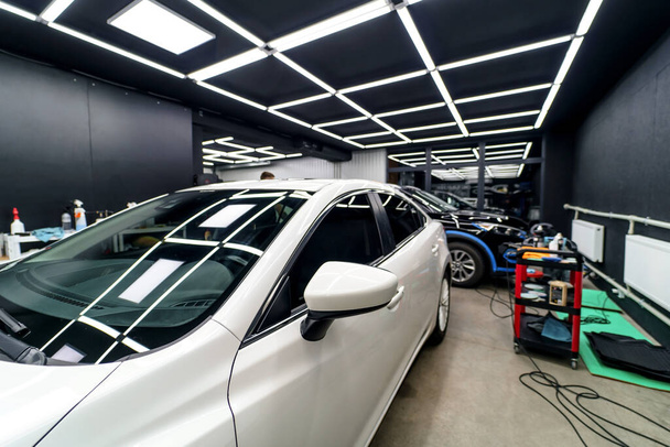 White car in the garage of the service station. Car detailing studio - Foto, Imagen