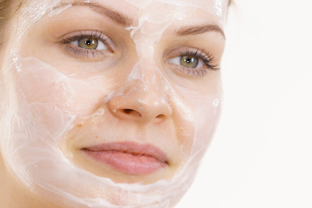 Young woman with cream cosmetic, mask moisture on her face. Beauty treatment. Skincare. - Zdjęcie, obraz