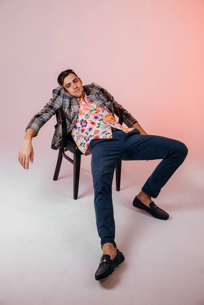 Back in time 90s 80s lifestyle concept. Studio footage of stylish cheerful young man in vintage retro jacket on light pink background, candy-colored fashions, creativity, emotions, facial expression - Photo, Image