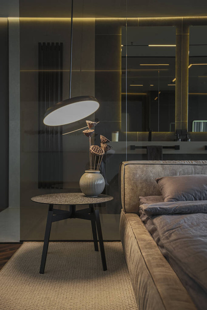 cool expensive interior design of room in prestigious luxury hotel with dark tones with modern LED lighting and stylish furniture. the area with a sink is separated by dark glass from the bedroom - Zdjęcie, obraz