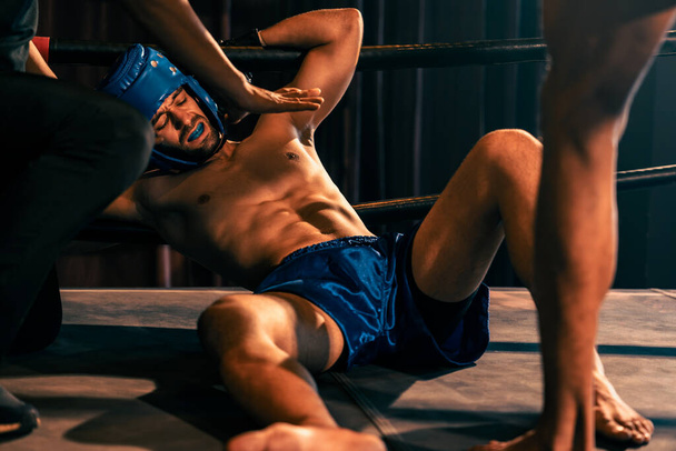 Nyrkkeilytuomari puuttuu asiaan pysäyttäen taistelun kaatuneen kilpailijan tarkistamiseksi. Voimakas ja kova nyrkkeilyottelu erotuomarin kanssa keskeyttää nyrkkeilijätaistelijoiden turvallisuuden. Virikkeitä - Valokuva, kuva
