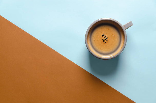 Cup of coffee on blue and brown background. Top view. - Φωτογραφία, εικόνα