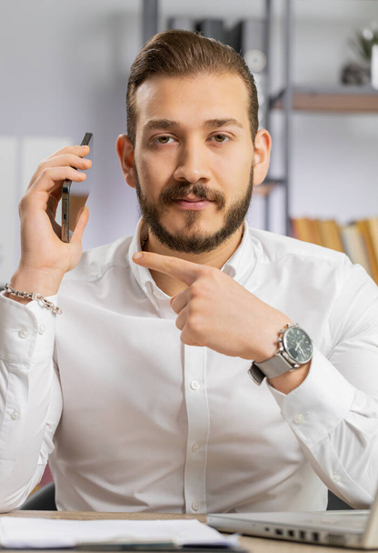 Call me. Middle eastern boss business man showing smartphone asking to make telephone conversation, gesturing call me sign, online date. Freelancer guy at office workplace looking at camera. Vertical - Photo, Image