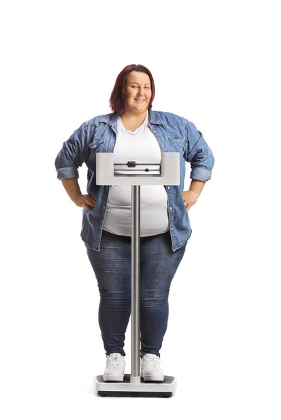 Overweight woman weighing on a medical scale isolated on white background - 写真・画像