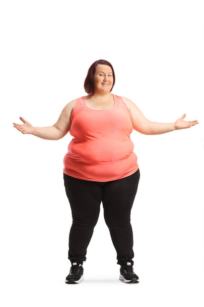 Overweight young woman in sportswear standing and smiling isolated on white background - Photo, image