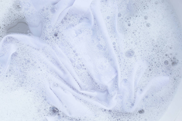 Top view of formal shirts soak in powder detergent water dissolution. Laundry concept - Φωτογραφία, εικόνα