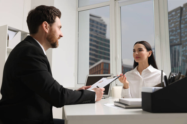 Human resources manager conducting job interview with applicant in office - Foto, afbeelding