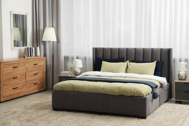 Stylish bedroom interior with large comfortable bed - Fotó, kép