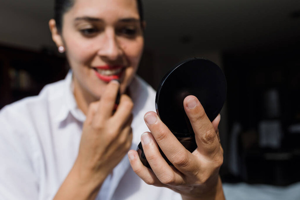 Latina mulher adulta colocando maquiagem em seu rosto, usando escovas cosméticas em casa no México, pessoas morenas hispânicas - Foto, Imagem