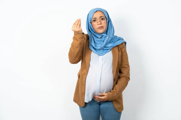 Mujer embarazada musulmana infeliz usando hijab hace gesto suicida e imita arma con la mano, los labios curvas mantiene dos dedos en la sien, dispara, estar cansado de todo, - Foto, Imagen