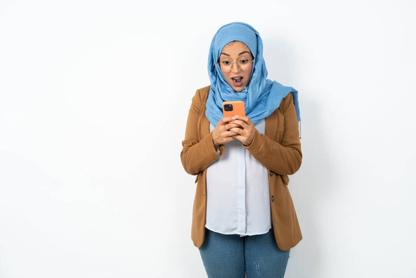 beautiful pregnant muslim woman wearing hijab  using mobile phone chatting free time . - Фото, изображение
