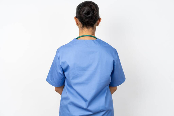 The back view of arab doctor woman wearing blue uniform . Studio Shoot. - Photo, image