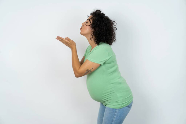 Profile side view of attractive pregnant woman sending air kiss - Photo, Image