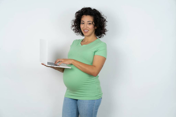 Suloinen raskaana oleva nainen, jolla on moderni kannettava tietokone - Valokuva, kuva