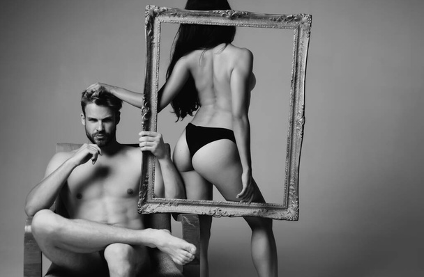 Brutal man holding frame. Young beautiful couple in love. Passionate heterosexual couple in love. Valentines day. Fashion photo of sexy elegant couple in the tender passion - Фото, изображение