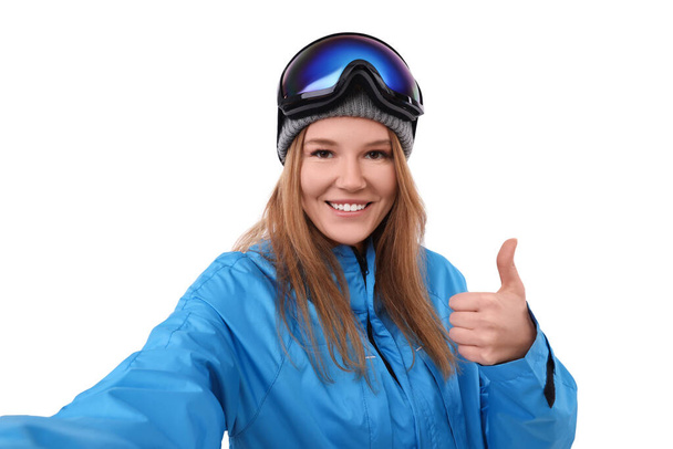 Beautiful woman in ski goggles taking selfie on white background - Fotó, kép