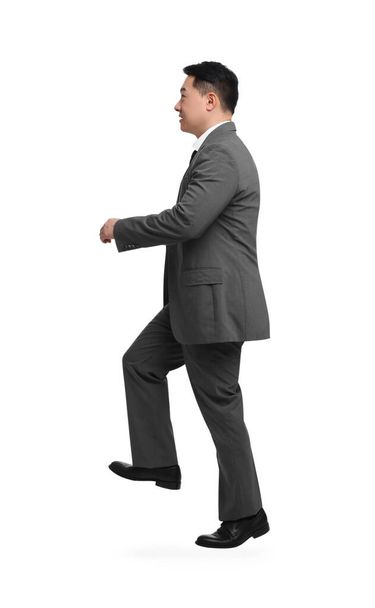 Businessman in suit walking on white background - Photo, image