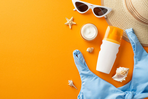 Das Konzept des Monats der UV-Sicherheit. Foto von oben: Strohhut und Badeanzug, Meeresmuscheln und Sonnenbrille und Sonnenschutzspray auf orangefarbenem Hintergrund mit Kopierraum - Foto, Bild