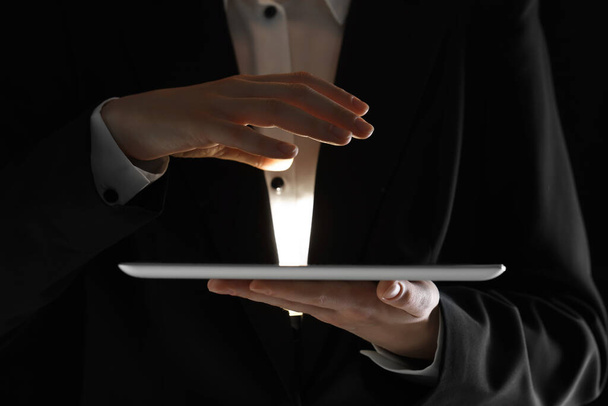Closeup view of man using modern tablet on black background - Zdjęcie, obraz