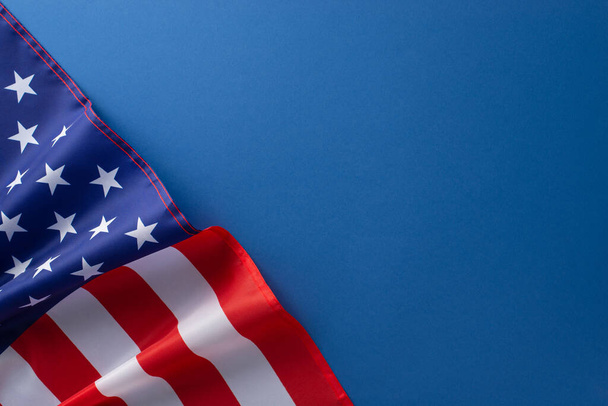 Американский федеральный праздник. Высокоугловая фотография американского флага на голубом изолированном фоне с копировальным пространством - Фото, изображение