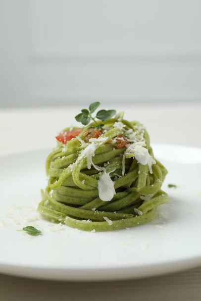Tasty tagliatelle with spinach and cheese on plate, closeup. Exquisite presentation of pasta dish - Fotó, kép