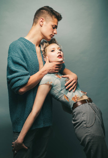 Affectionate couple while a photo session. Relax. Tender picture of young couple. Fashion studio photo of beautiful couple. Valentines day. Sensuality. Isolated on grey - Фото, зображення