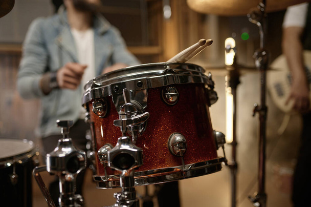 Repetição de ensaios da banda de rock. Closeup de baquetas deitado no tambor conjunto baterista equipamento foco seletivo - Foto, Imagem
