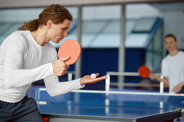 Mężczyźni i kobiety grający w tenisa stołowego, skupiają się na sportowcu podającym piłkę z rakietą. Sport i koncepcja zdrowego stylu życia - Zdjęcie, obraz