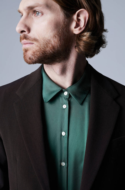 Minimal profile shot of handsome young man wearing trendy suit with teal green silk shirt - Foto, Bild