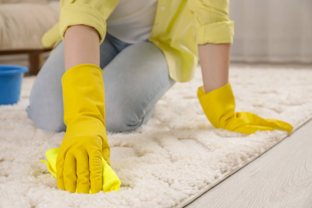 Woman in rubber gloves cleaning carpet with rag indoors, closeup - Fotografie, Obrázek