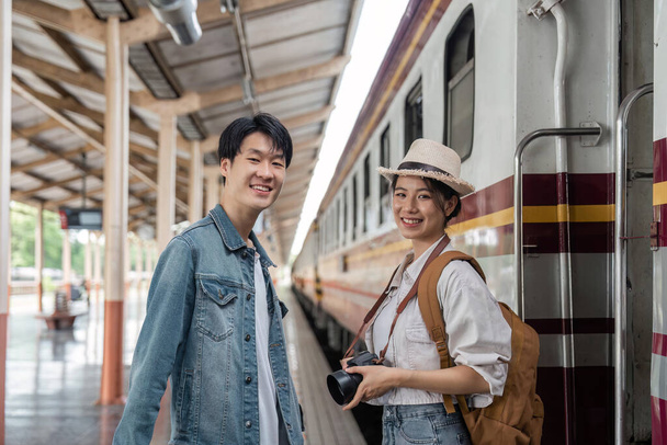 Asyalı çift gezginleri, sırt çantalı gezginler, tren istasyonunda birlikte. Turizm etkinliği ya da demiryolu seyahat kavramı. - Fotoğraf, Görsel
