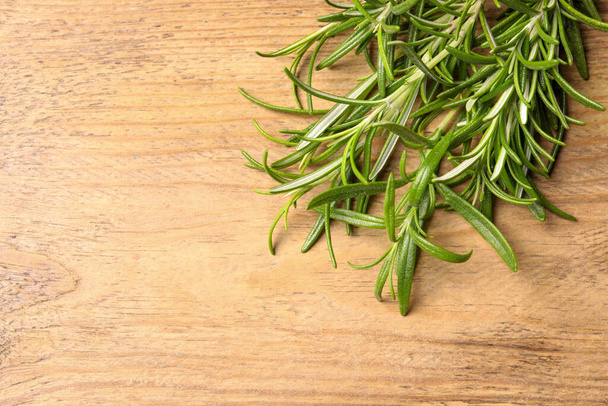 Fresh green rosemary on wooden table, top view. Space for text - 写真・画像