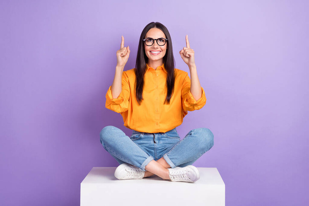 Full size photo of good mood nice woman yellow shirt jeans indicating look at discount empty space isolated on violet color background. - Fotó, kép